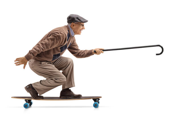 istock Elderly man riding a longboard and holding a cane 982550266
