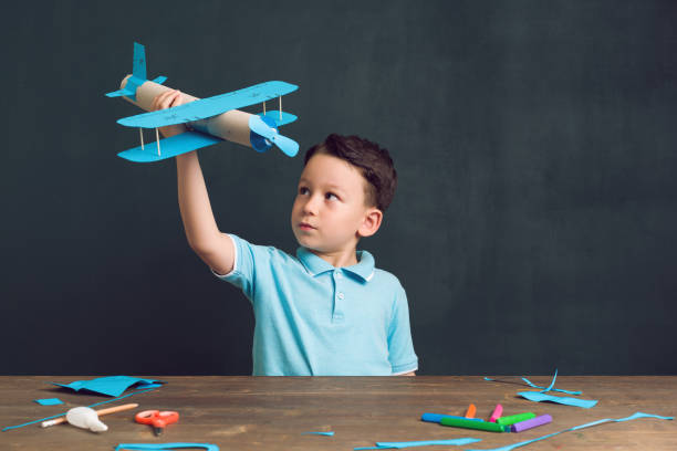 The child making a plane. He used cardboard and paper. This is an innovation for his. He is a successful student at the age of 4-5.
