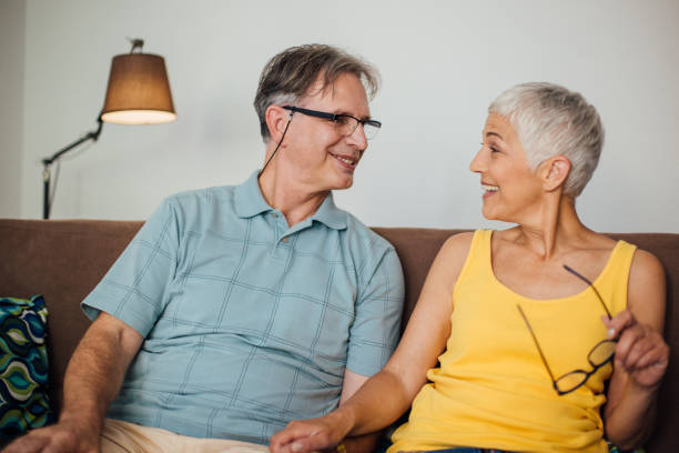 istock Happy married couple sitting on sofa 982559658