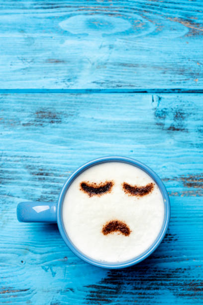 istock cup of cappuccino with a sad face 982580494