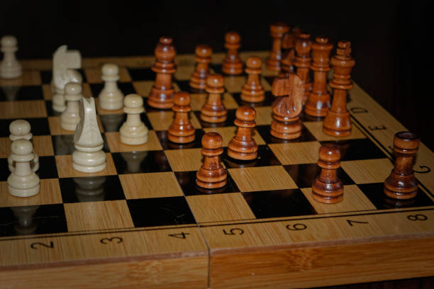 istock Wooden material chess board and chess pieces in low light 982608848