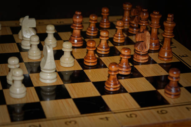 istock Wooden material chess board and chess pieces in low light 982614302
