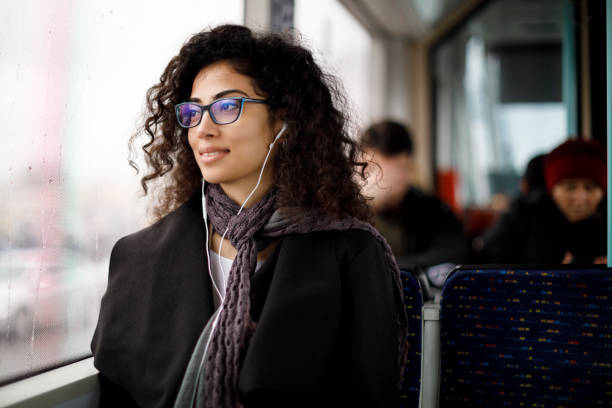 giovane donna che si sposta con i mezzi pubblici - bus transportation indoors people foto e immagini stock