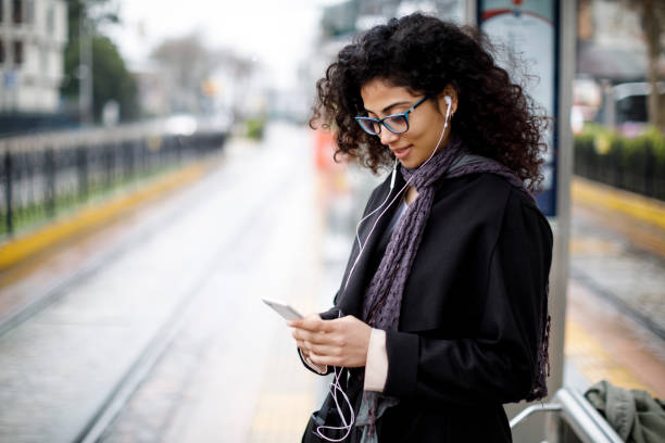 woman waiting for train at the station - urban scene commuter business station imagens e fotografias de stock