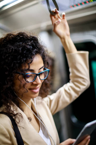 istock Young businesswoman using smartphone while commuting to work by subway 982638036