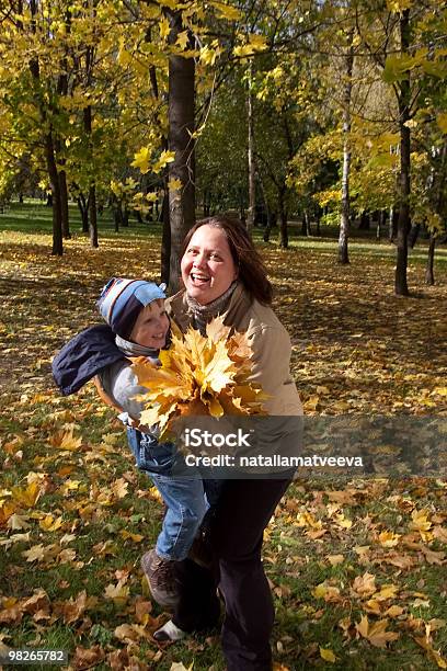 Мать И Сын В Осенний Парк — стоковые фотографии и другие картинки Букет - Букет, Вертикальный, Веселье
