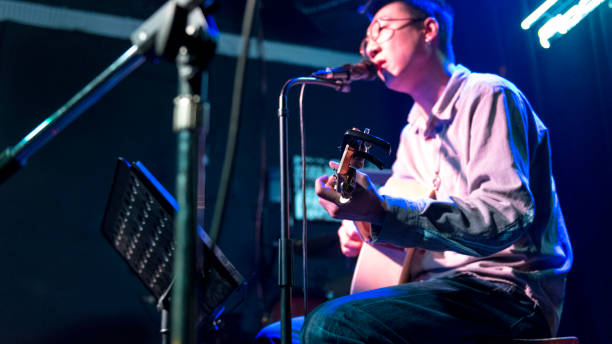 canta un cantante masculino en el bar de música china. - suit jeans men musician fotografías e imágenes de stock