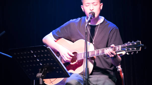 canta un cantante masculino en el bar de música china. - suit jeans men musician fotografías e imágenes de stock