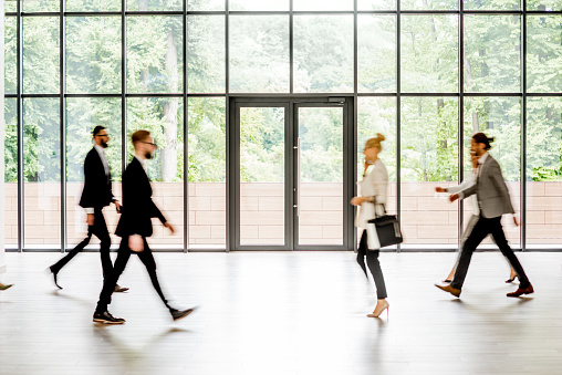 Business people walking at the modern hall on the window background indoors. long exposure image technic with motion blurred people