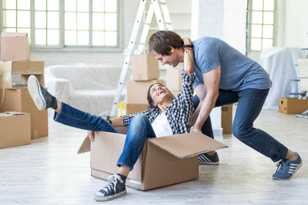 istock Happy couple in new home unpacking and having fun 982680106