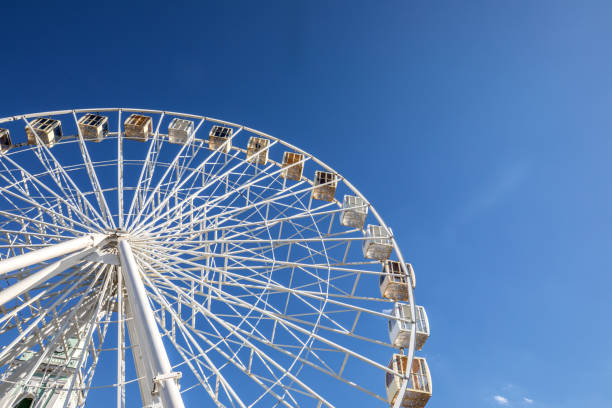 istock Big ferris wheel against the blue sky. 982735580