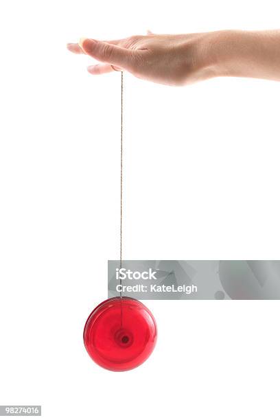 Red Yoyo Dangling From A Hand On A White Background Stock Photo - Download Image Now