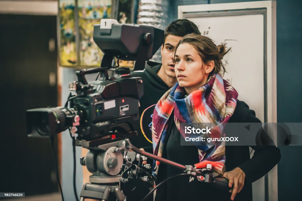 Detrás de la escena. Camarógrafo y asistente de rodaje de película con cámara - Foto de stock de Estudiante libre de derechos