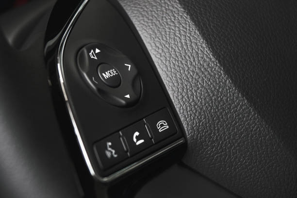 istock Modern car interior, gray steering wheel with media phone control buttonsto accept or reject calls. 982749622