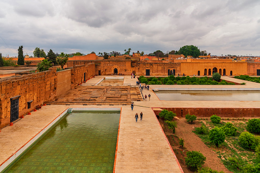 El Badi Palace in Marrakech, Morocco. Photo contains tourists visiting the courtyard of the palace.