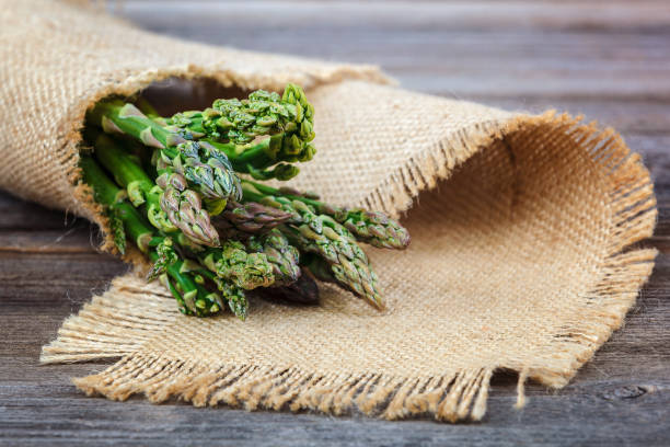 istock Asparagus green fresh on a wooden background 982773388