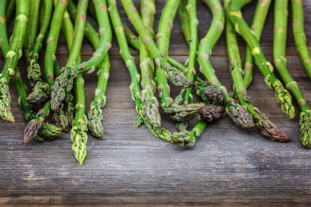 istock Asparagus green fresh on a wooden background 982773678