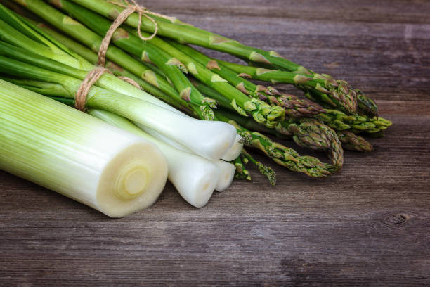 istock Asparagus and onion green on a wooden background 982774468