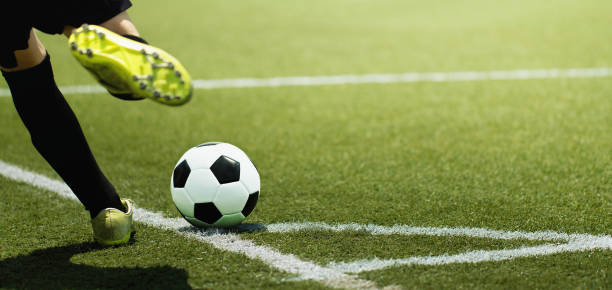 pie de un niño jugador del balompié y bola en el campo de fútbol - patadas fotografías e imágenes de stock