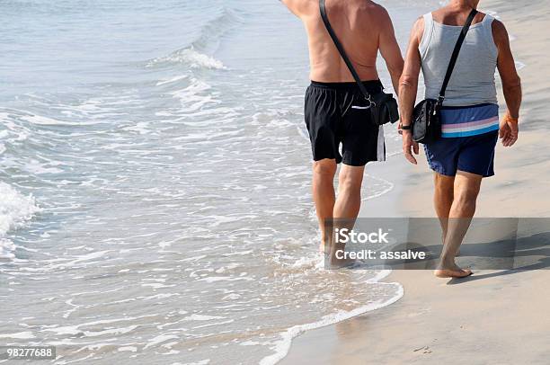 Foto de Caminhada Na Praia e mais fotos de stock de Duas pessoas - Duas pessoas, Tronco Nu, Vista Traseira