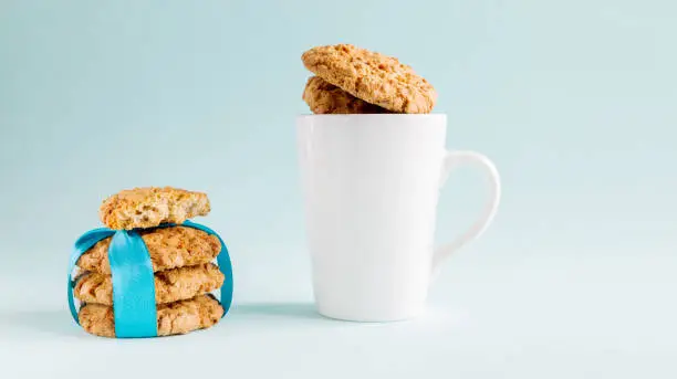 Fresh cookies and white mug on a blue background. Copy space