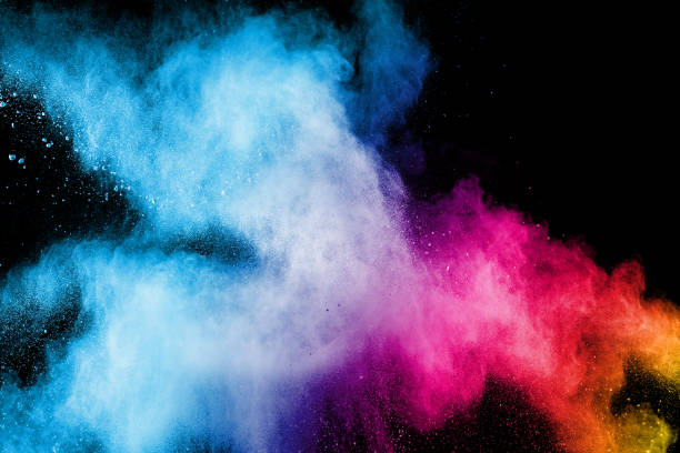 istock Multi color particles explosion on black background. Colorful dust splatter on dark background. 982780470