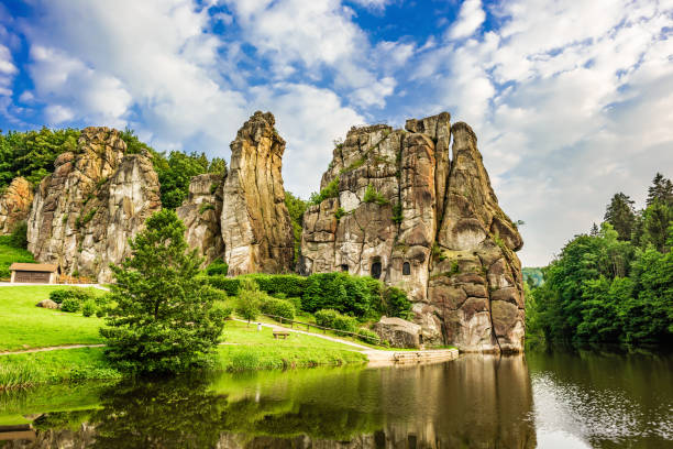 Externsteine in Teutoburg Forest, Germany Externsteine with lake and park in Teutoburg Forest, Germany detmold stock pictures, royalty-free photos & images