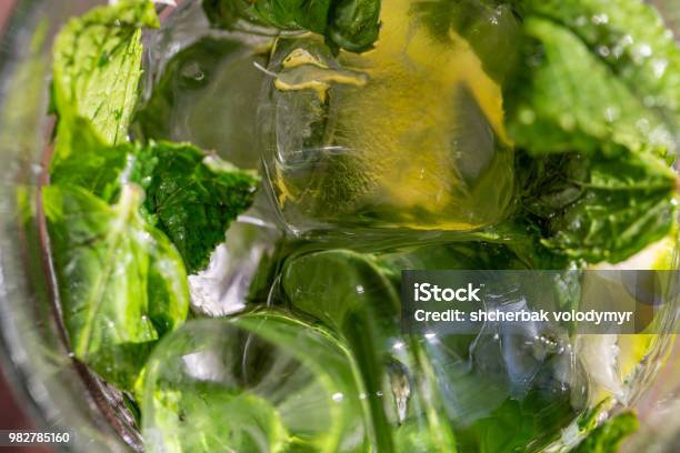 Twigs Green Mint In Mojito With Slices Lime Ice Cubes Straw Macro Texture Stock Photo - Download Image Now