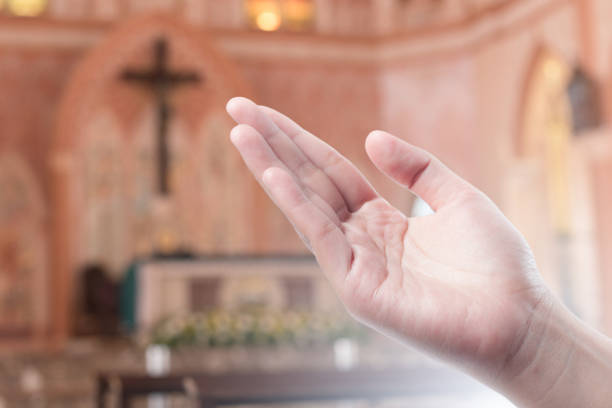 istock Human open empty hand with palms up(Praying Hand) on blurred church interior background 982789206