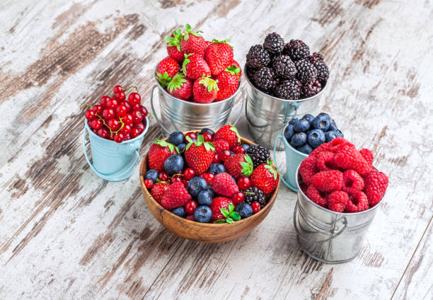 istock Berries fresh in tin cans arrangement on white wooden table 982796496