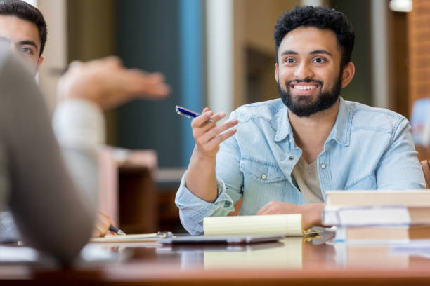 istock Young man talks with unrecognizable college friend 982800468