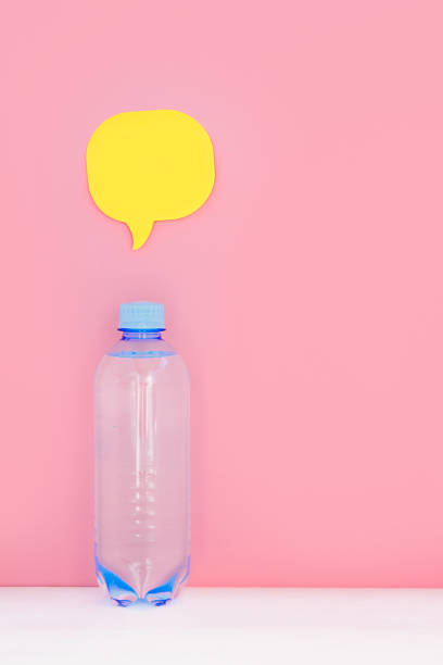 istock bottle of clear water on a pink background, above it a sticker for writing text 982804378