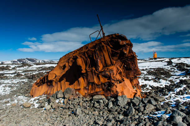 istock Deep blue sky is covering a crashed ship wreck with a striking orange lighthouse in the Background 982812496
