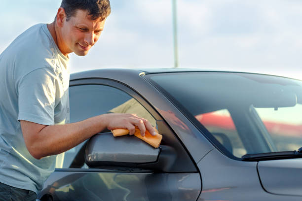 istock Cleaning like a professional- man cleaning his car with a microfiber cloth 982815762