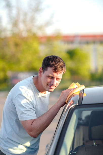 istock Cleaning like a professional- man cleaning his car with a microfiber cloth 982815906
