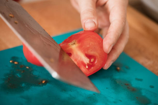 istock Tomato cut at cutting board, close-up 982816108