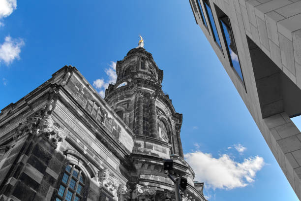 historical cross church in Dresden and a modern building, abstract, black and white with blue sky
