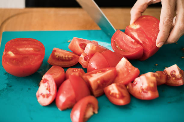 istock Tomato cut at cutting board, close-up 982822596