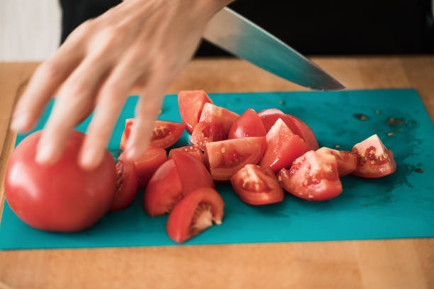 istock Tomato cut at cutting board, close-up 982823356