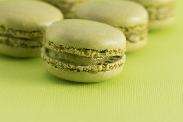 istock Green French Macarons on a Green Background 982838478