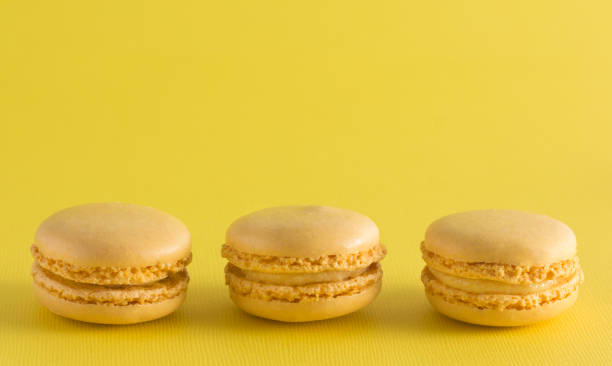 istock Yellow French Macarons on a Yellow Background 982841244