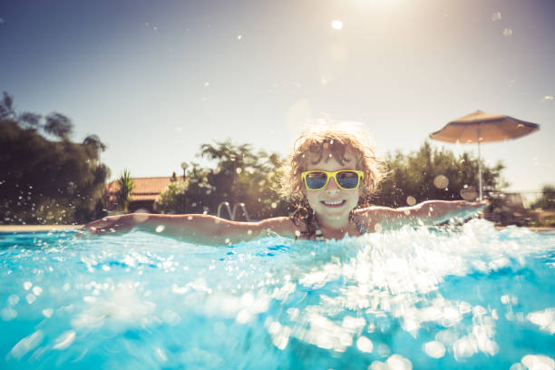 istock Child playing in swimming pool 982845582