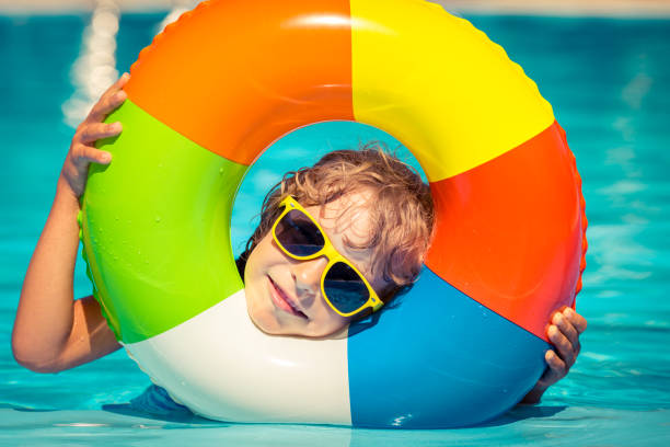 istock Child playing in swimming pool 982845612