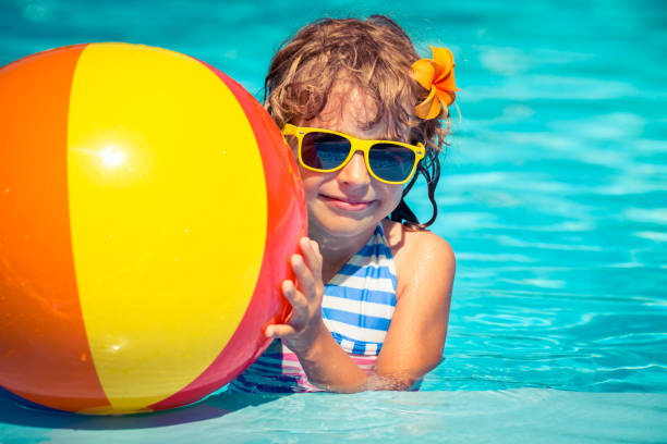 istock Child playing in swimming pool 982845700