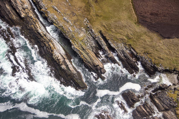 波は南大西洋のフォークランド諸島の岩の多い海岸線にぶつかります。 - falkland islands ストックフォトと画像