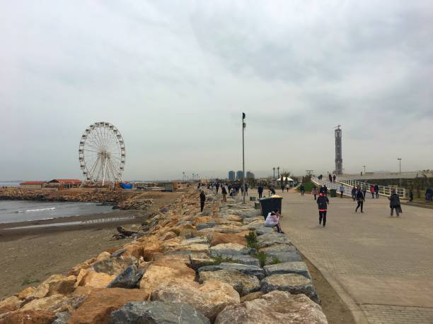 Sablettes, Algiers, Algeria - April 13, 2018: Algerian people are walking beside Ferris Wheel and Grand Mosque of Algiers near by Mediterranean Sea.