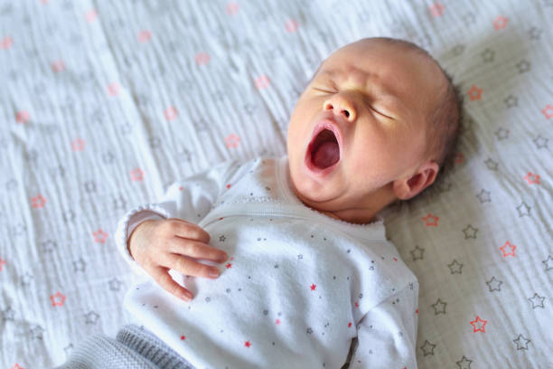 Newborn baby girl yawning stock photo