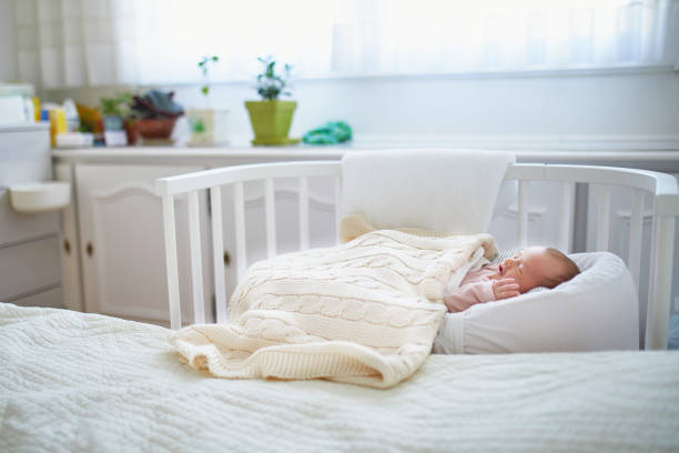 istock Newborn baby having a nap in co-sleeper crib 982891636