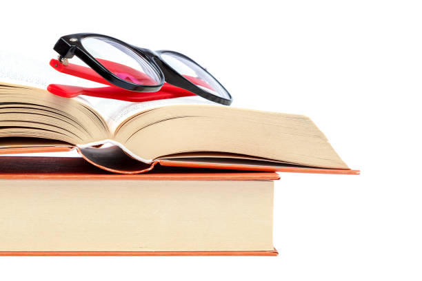 istock Open book and glasses on a stack of books 982895702