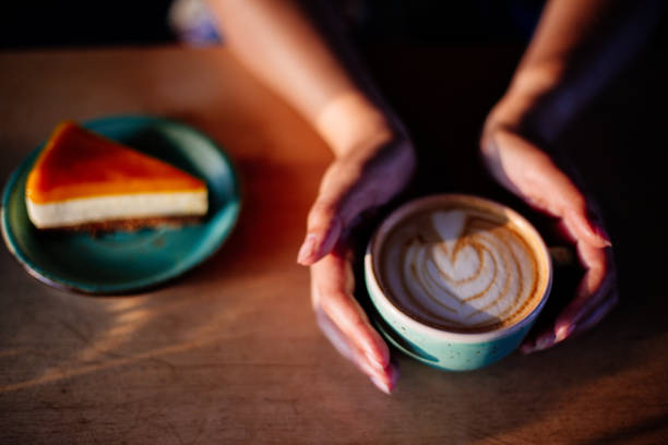 istock Cup of cappuccino in hands. 982895946